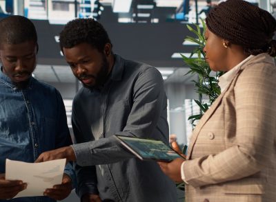 Professional team analyzing archived data on a financial file during meeting, collaborating on enterprise solutions and solving tasks to improve performance for long term growth. Camera A.